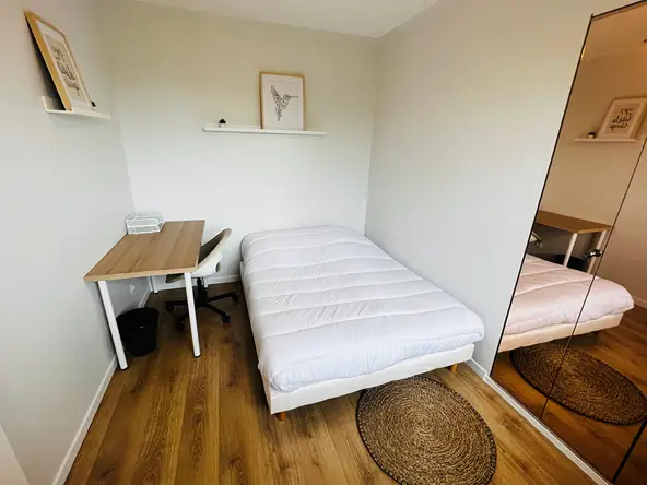 Chambre meublée avec lit double, bureau et placard miroir — colocation Villeurbanne